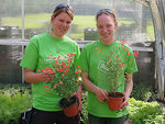 Zwei Frauen präsentieren Pflanzen.
