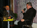 Dr. Herbert Keßler und George Nussbaumer sitzen gemeinsam auf einer Bühne.